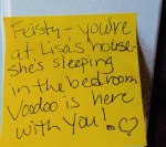 A yellow sticky note with handwritten text: "Feisty - you're at Lisa's house - she's sleeping in the bedroom. Voodoo is here with you!" followed by a small drawing of a heart and infinity symbol.